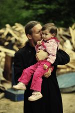 Parintele Mihai Nita cu un copil, o fetita in brate - Fotografii cu copiii din Valea Plopului - Valea Screzii